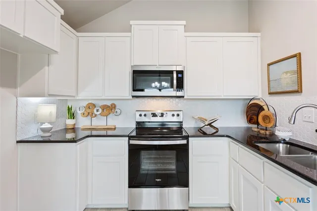 a kitchen with stainless steel appliances granite countertop a sink stove and microwave