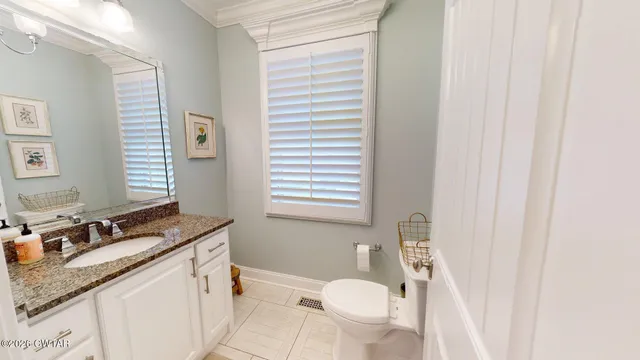 a bathroom with a granite countertop sink toilet and mirror