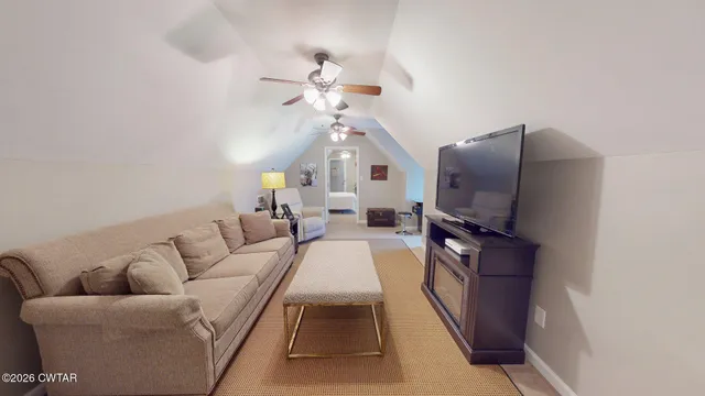 a living room with furniture a flat screen tv and a chandelier