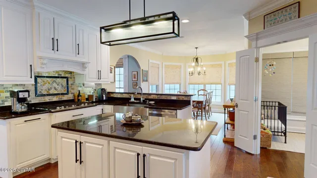 a kitchen with stainless steel appliances granite countertop a sink a stove and cabinets