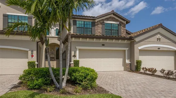front view of a house with a yard and palm trees