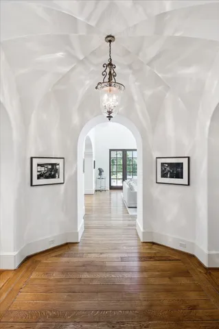a view of a hallway with wooden floor and staircase