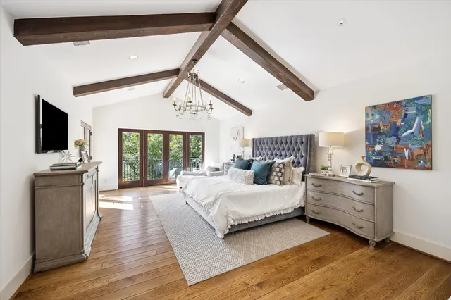 a spacious bedroom with a bed and a flat screen tv