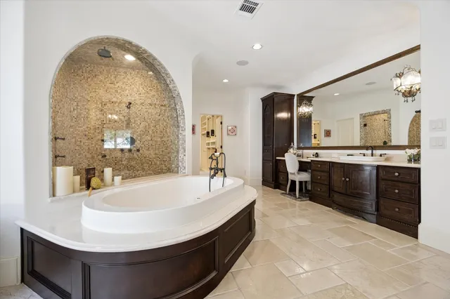 a spacious bathroom with a tub sink and mirror