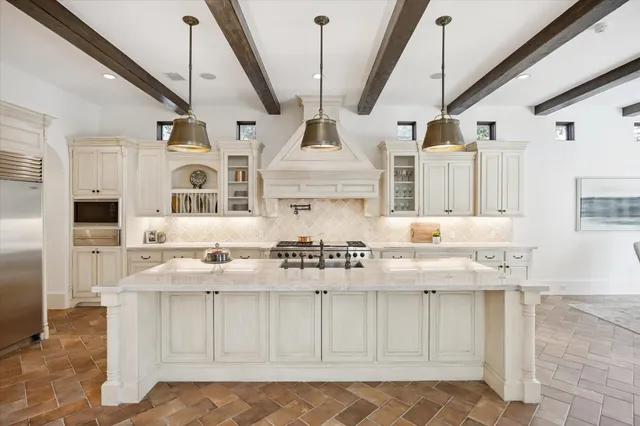 a kitchen with stainless steel appliances kitchen island granite countertop a stove and a sink