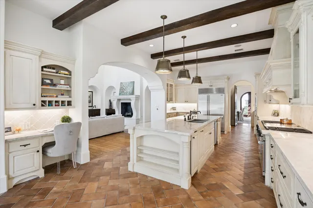 a large white kitchen with stainless steel appliances