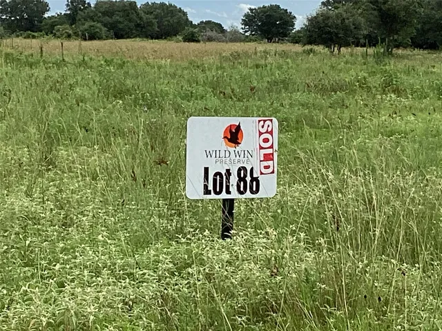 a sign that is sitting on a lush green field
