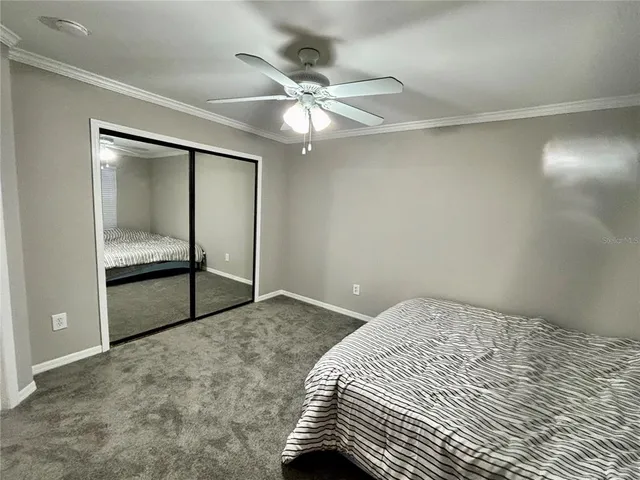 a bedroom with a bed and a ceiling fan