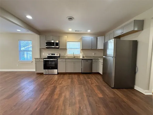 a kitchen with stainless steel appliances granite countertop a sink and a microwave