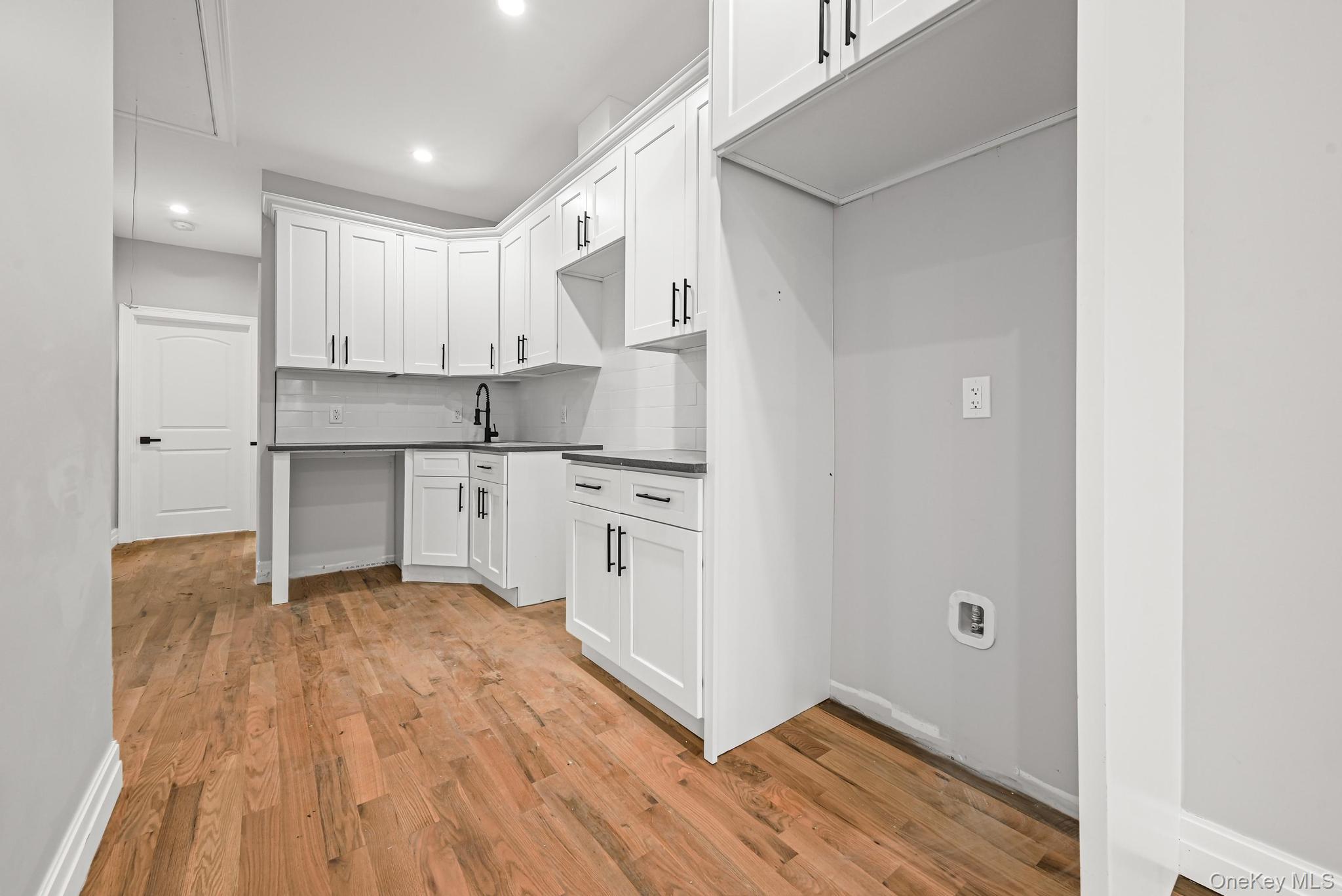 160-15 118th Road Queens, NY 11434 - Photo 7 of 23 a kitchen with white cabinets and sink