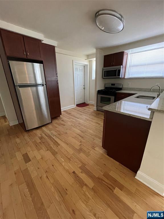 280-320 Oak Street, Unit 306TG Ridgewood, NJ 07450 - Photo 7 of 22 a kitchen with stainless steel appliances wooden floors and wooden cabinets
