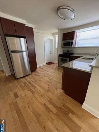a kitchen with stainless steel appliances wooden floors and wooden cabinets