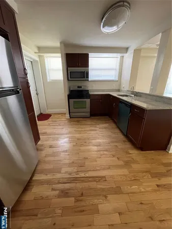 a view of kitchen with wooden floor and electronic appliances
