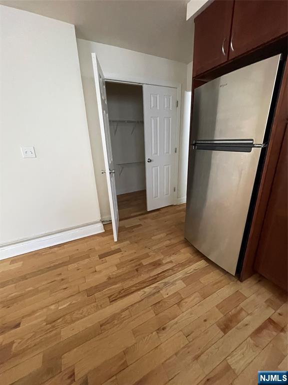280-320 Oak Street, Unit 306TG Ridgewood, NJ 07450 - Photo 9 of 22 an empty room with wooden floor and a refrigerator
