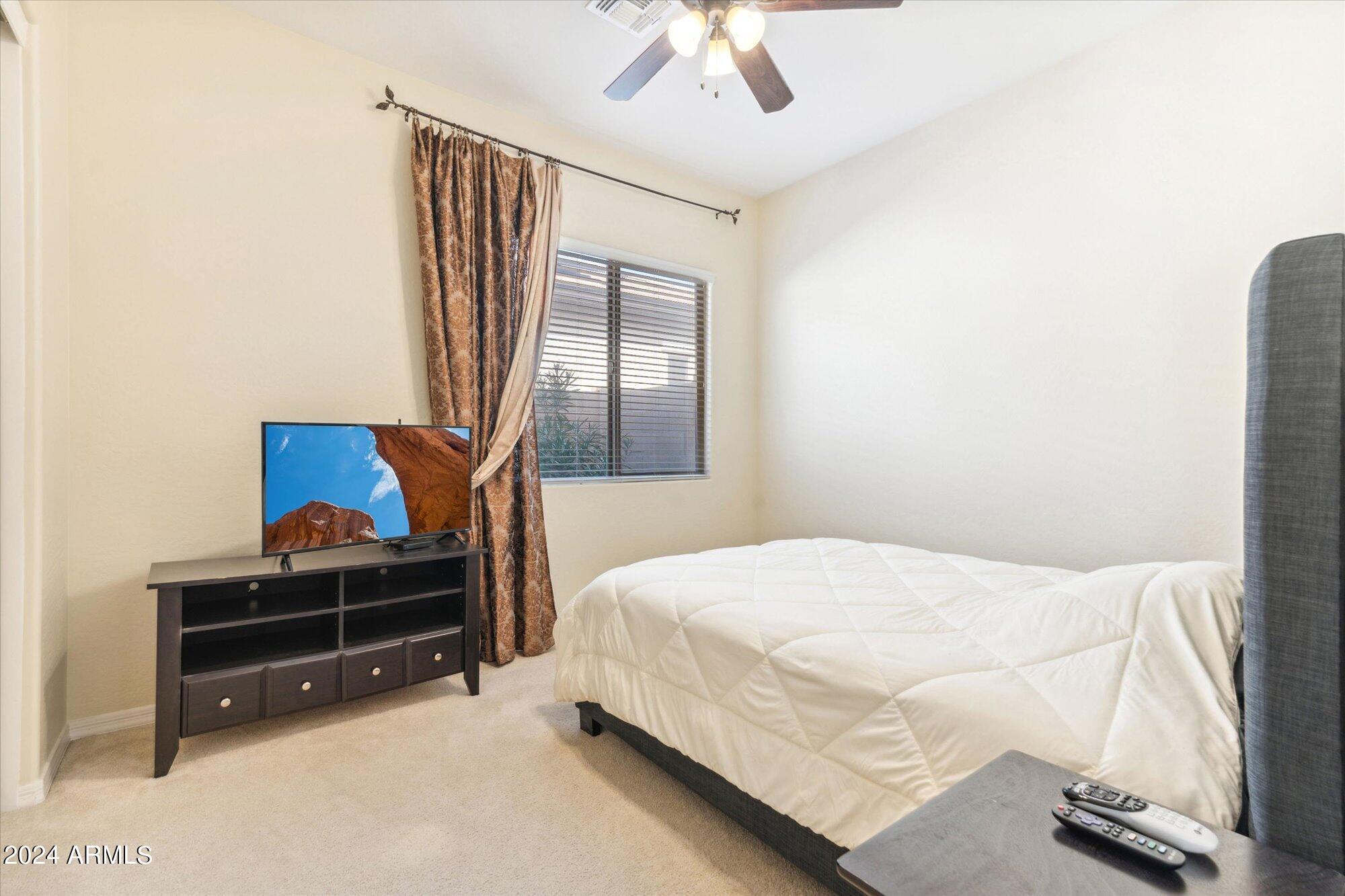 3307 North Riverside Drive Florence, AZ 85132 - Photo 13 of 35 a bedroom with a bed and a chandelier