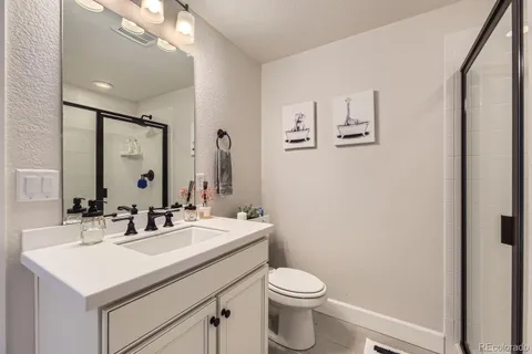 a bathroom with a sink mirror vanity and toilet