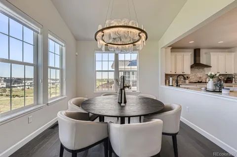 a view of a dining room with furniture a chandelier and wooden floor
