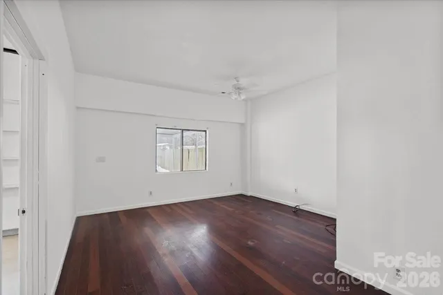an empty room with wooden floor and cabinet