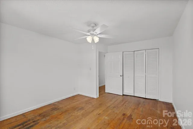 a view of an empty room with chandelier fan