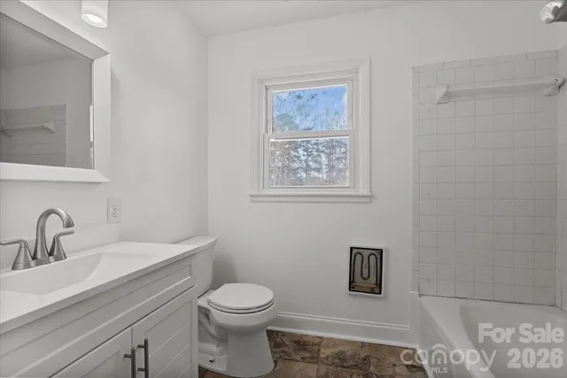 a bathroom with a toilet sink vanity and mirror
