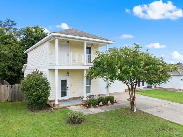 a front view of a house with a yard and trees