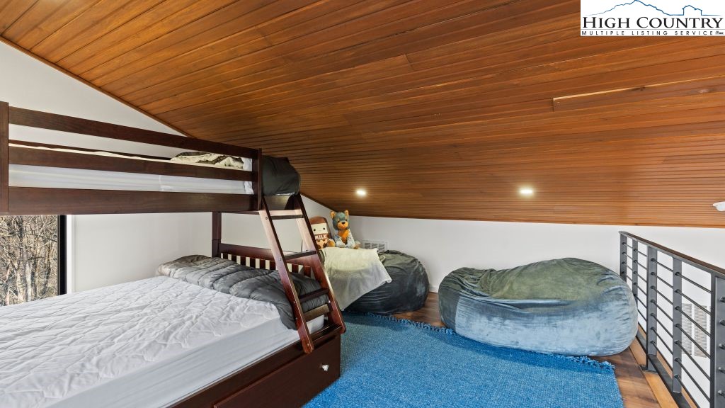 114 Windridge Road Beech Mountain, NC 28604 - Photo 11 of 49 a bed sitting in a bedroom next to a window