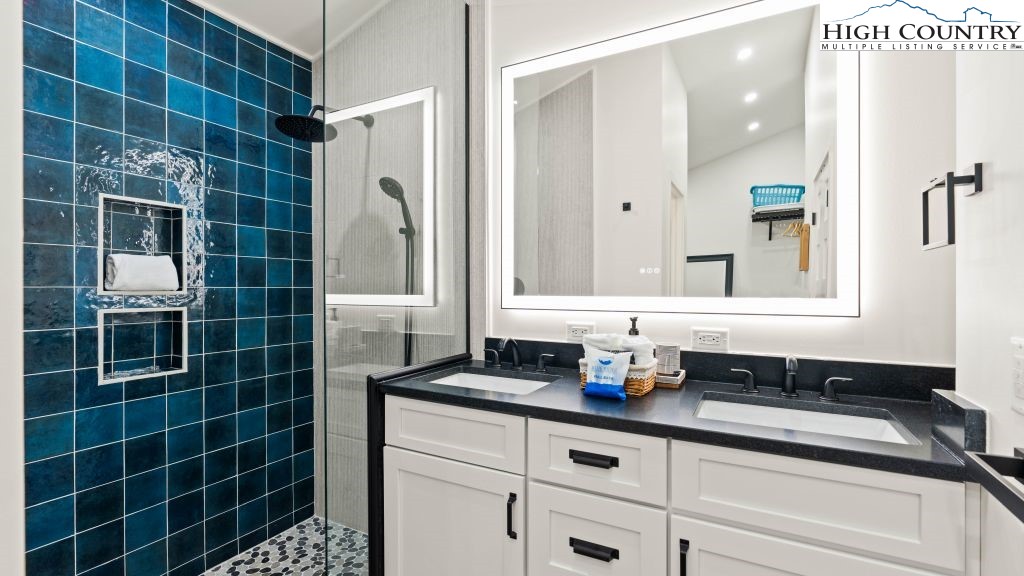 114 Windridge Road Beech Mountain, NC 28604 - Photo 19 of 49 a bathroom with a double vanity sink a mirror and a shower