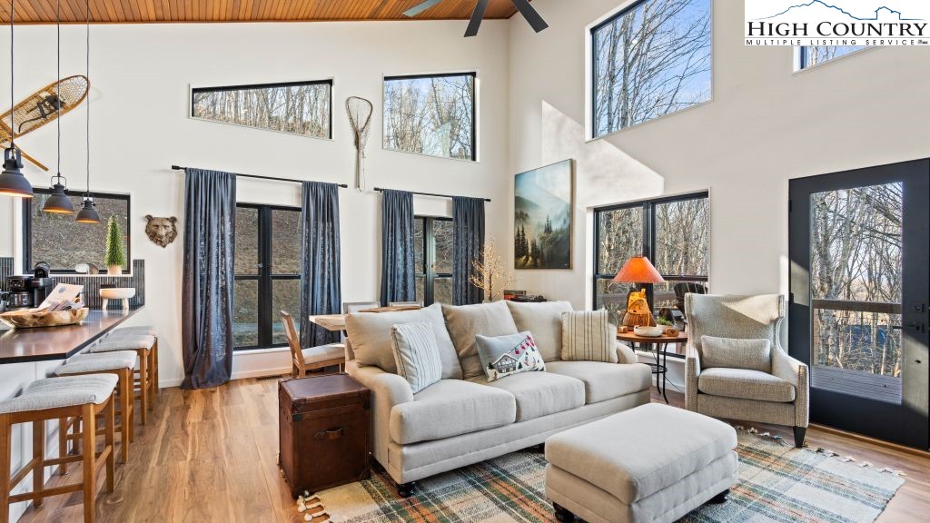 114 Windridge Road Beech Mountain, NC 28604 - Photo 2 of 49 a living room with furniture a flat screen tv and a floor to ceiling window