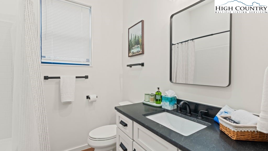 114 Windridge Road Beech Mountain, NC 28604 - Photo 24 of 49 a bathroom with a granite countertop sink mirror vanity and toilet