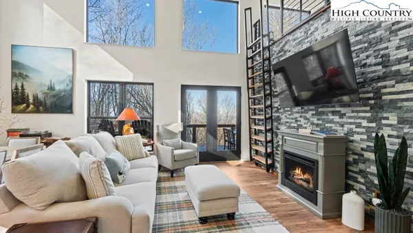 a living room with furniture a flat screen tv and a fireplace