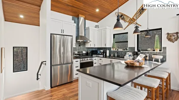 a kitchen with stainless steel appliances granite countertop a sink refrigerator and cabinets