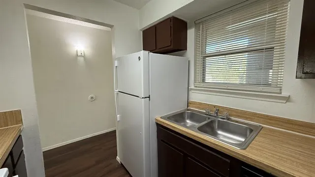 a kitchen with a sink a refrigerator and cabinets