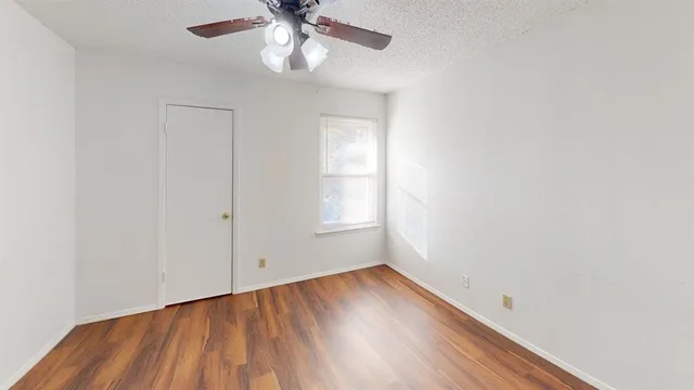 an empty room with a window and wooden floor