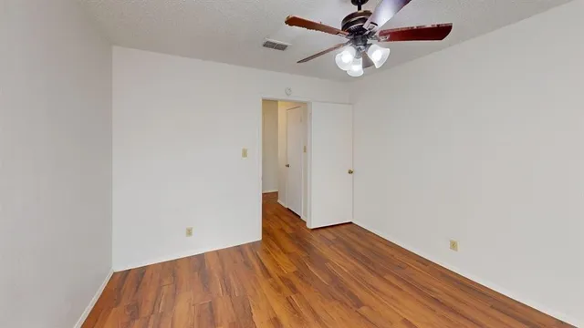 a view of room with window ceiling fan and wooden floor