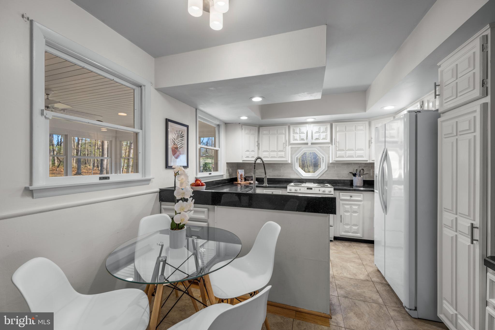 932 Western Chapel Road Westminster, MD 21157 - Photo 12 of 48 a kitchen with stainless steel appliances kitchen island granite countertop a dining table chairs and a refrigerator