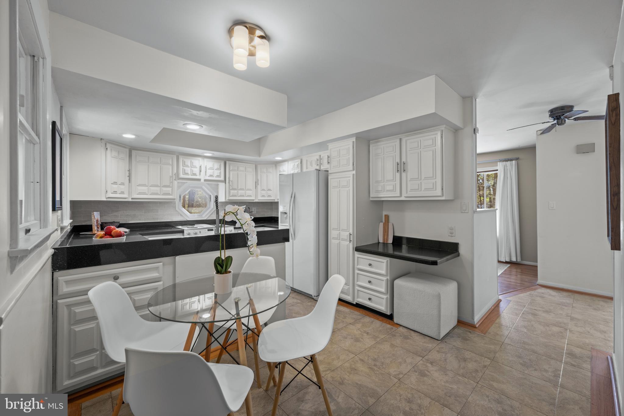 932 Western Chapel Road Westminster, MD 21157 - Photo 14 of 48 a kitchen with stainless steel appliances kitchen island granite countertop a dining table chairs refrigerator and sink