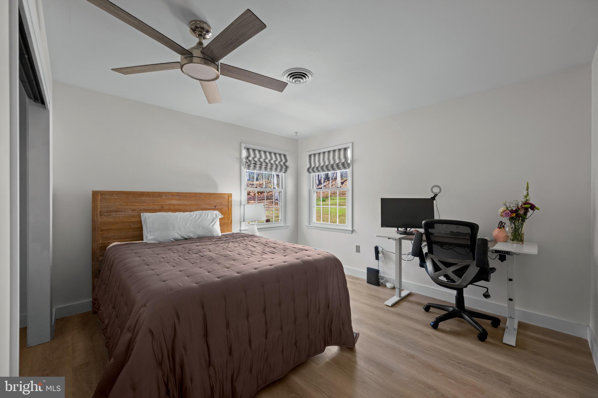 932 Western Chapel Road Westminster, MD 21157 - Photo 34 of 48 a bedroom with a bed a desk and chair with wooden floor