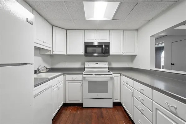a kitchen with cabinets stainless steel appliances a sink and wooden floor
