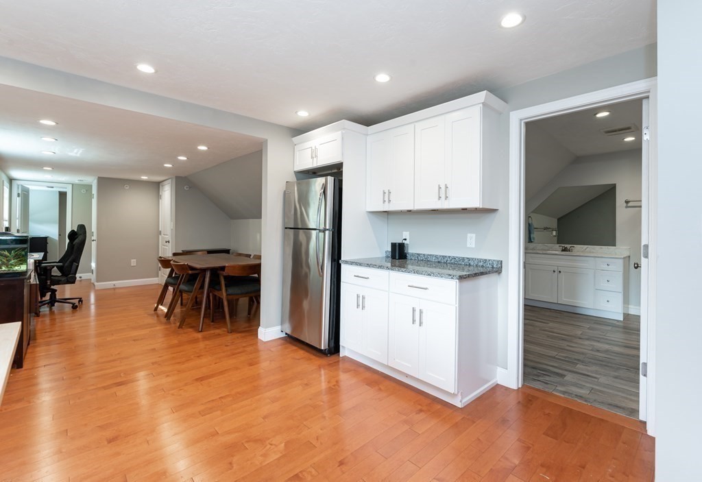 8 Putnam Street, Unit 3 Danvers, MA 01923 - Photo 10 of 32 a kitchen with stainless steel appliances kitchen island granite countertop a refrigerator and cabinets
