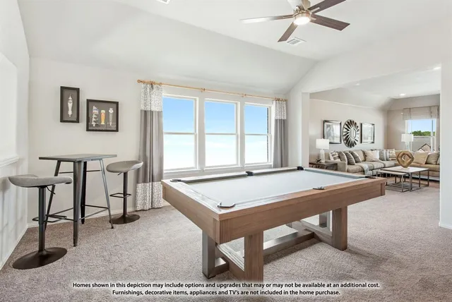 a room with furniture pool table and windows