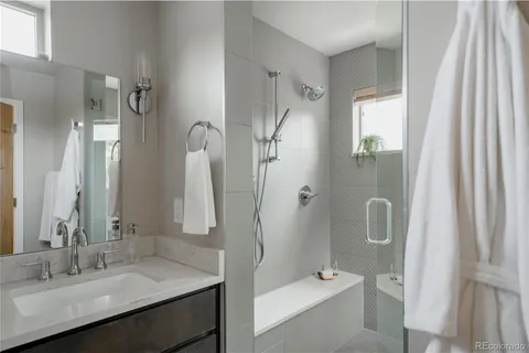 a bathroom with a granite countertop sink a toilet and shower