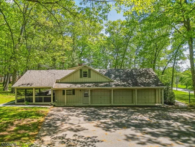 a white house with a big yard and large trees