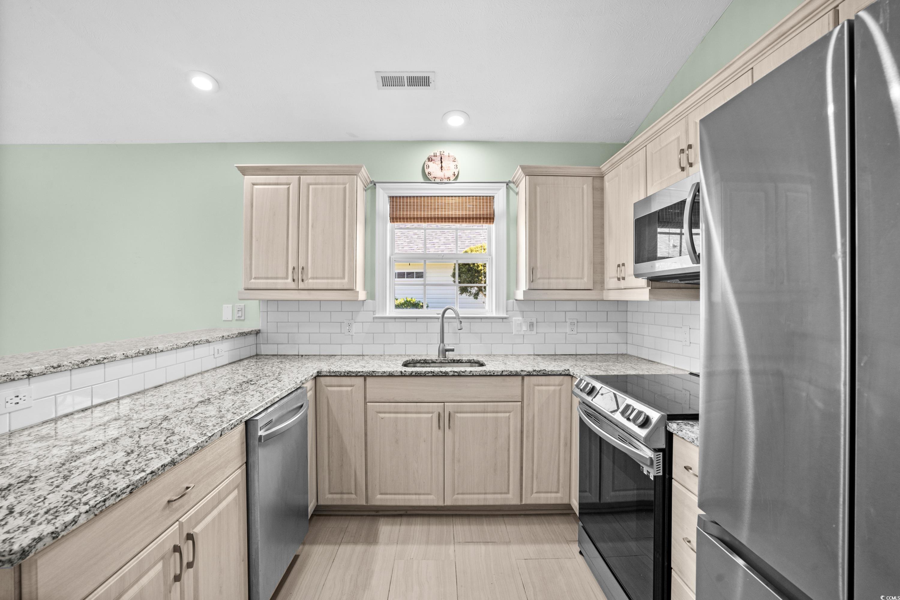 6028 Andros Lane' Murrells Inlet, SC 29576 - Photo 16 of 38 Kitchen with sink, light stone counters, kitchen p