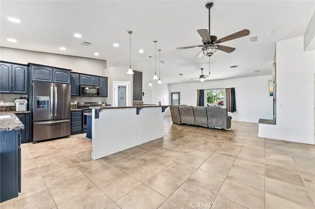 a large kitchen with stainless steel appliances kitchen island granite countertop a stove a sink a refrigerator and a oven