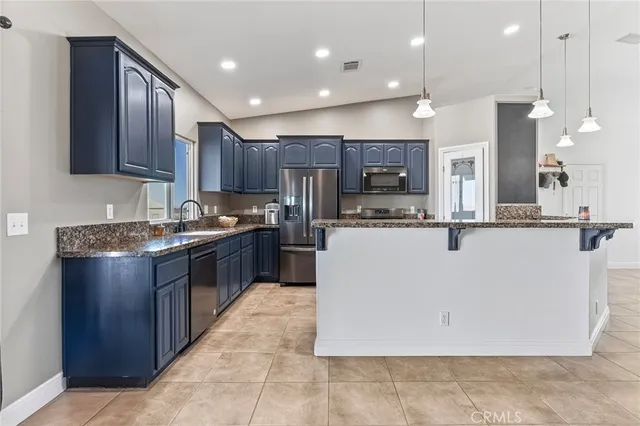 a kitchen with stainless steel appliances granite countertop a refrigerator and a sink