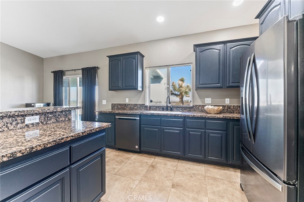 2700 Olivera Road Pinon Hills, CA 92371 - Photo 15 of 37 a kitchen with stainless steel appliances granite countertop a refrigerator and a sink