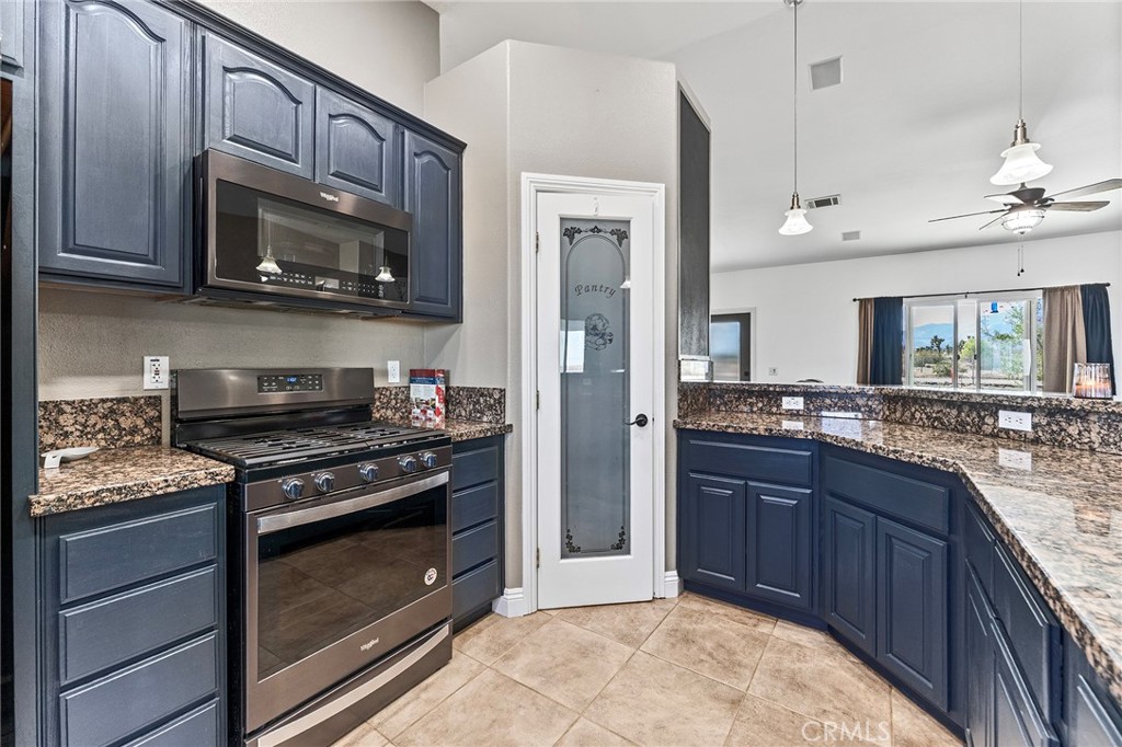 2700 Olivera Road Pinon Hills, CA 92371 - Photo 16 of 37 a kitchen with stainless steel appliances granite countertop a stove microwave and sink