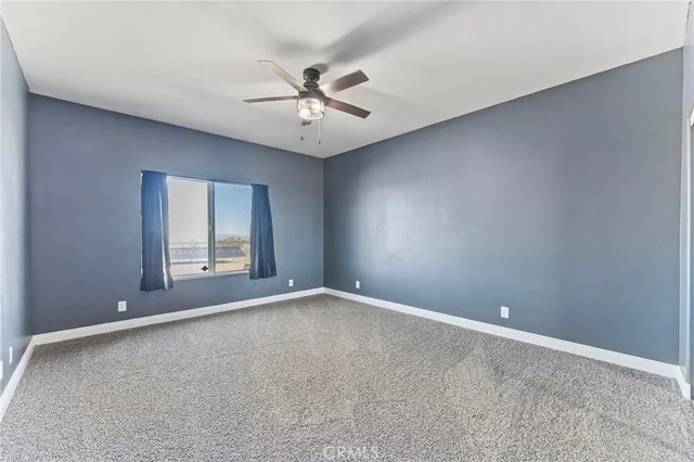 a view of an empty room with window and cabinet
