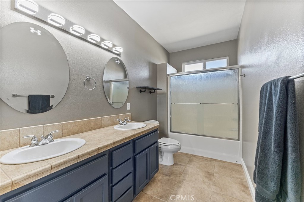 2700 Olivera Road Pinon Hills, CA 92371 - Photo 25 of 37 a bathroom with a double vanity sink toilet mirror and shower