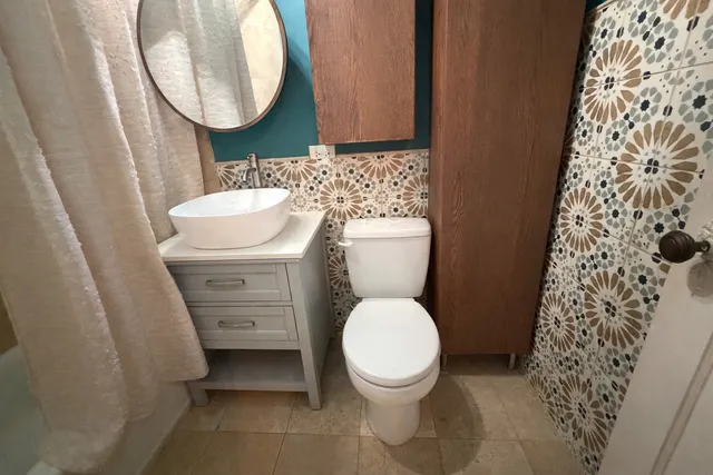 a bathroom with a granite countertop toilet sink and mirror